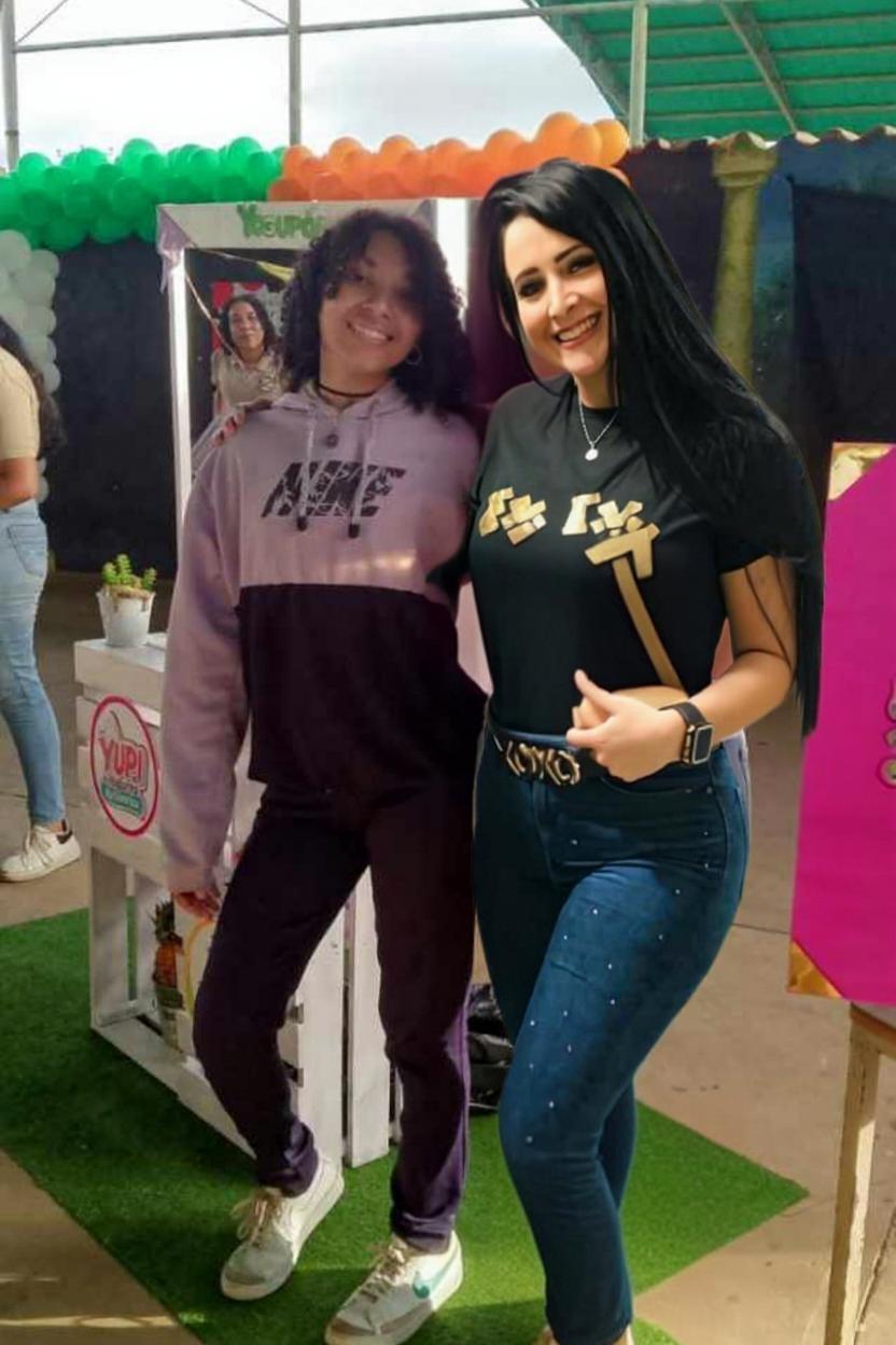 "Unifica el estilo visual de la imagen. Empareja la iluminación, el contraste y el tono de color entre ambas personas para que parezca que fueron fotografiadas en el mismo momento y lugar. Mantén los rostros intactos y no alteres la pose ni el fondo. Solo ajusta la luz, sombras y temperatura para que no se note diferencia entre las dos mitades."