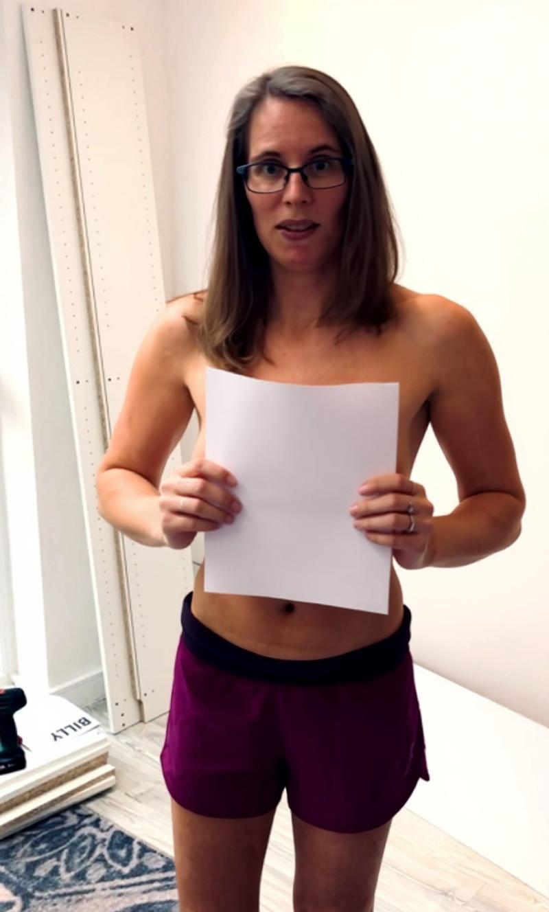she-is-holding-a-white-paper-next-to-her-face-the-ku97ktxe5p