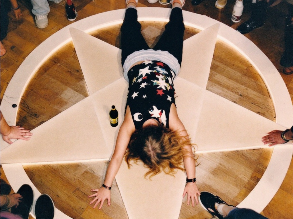 a-girl-laying-on-a-pentagram-at-a-party-kzs2240n4u