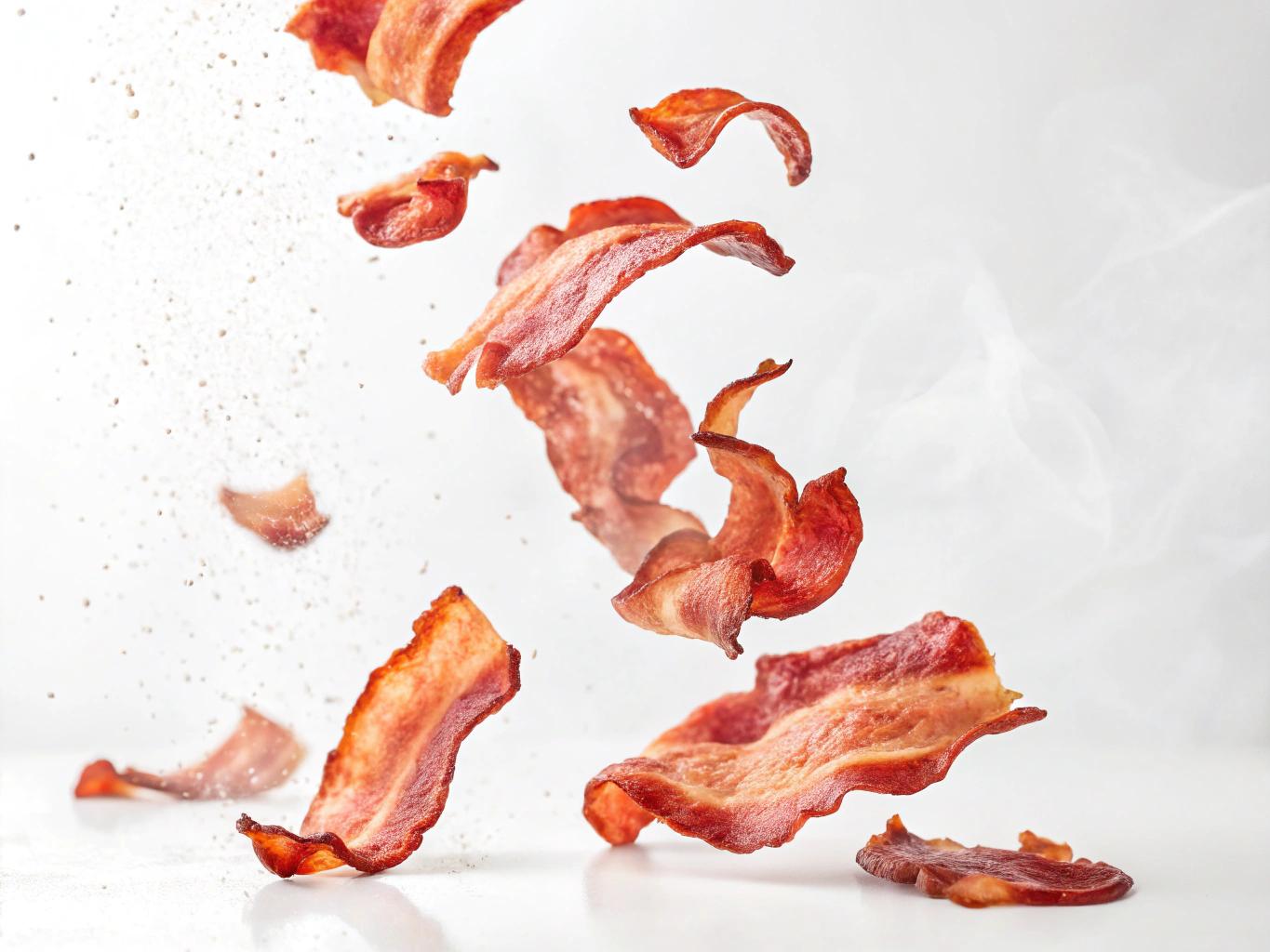 smoked  bacon pieces flying on a white background
