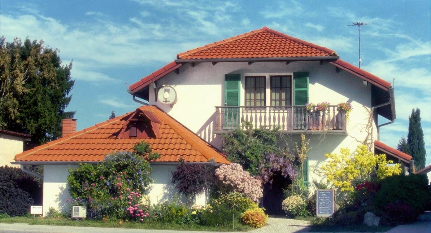 the-image-shows-a-two-story-house-with-a-red-tiled-1q4qre8i7