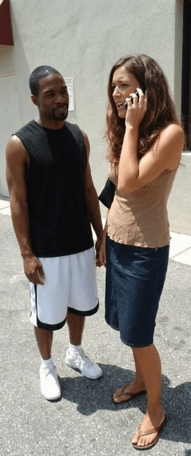 woman-talking-on-the-phone-while-a-black-man-k8merninj8